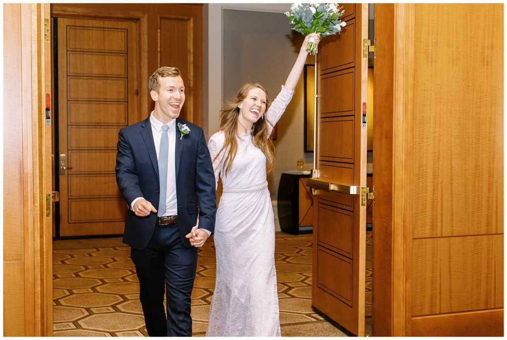 The bride and groom making their wedding reception entrance at the Umstead