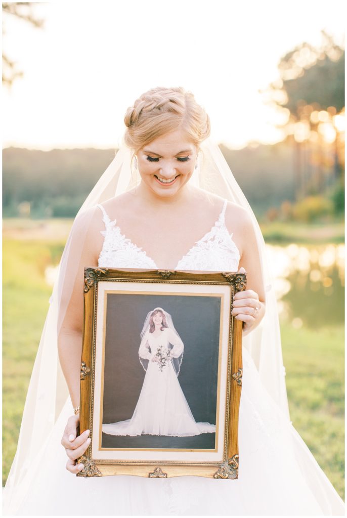 Bride holding a framed bridal portrait of her mother to gift to her on her wedding day
