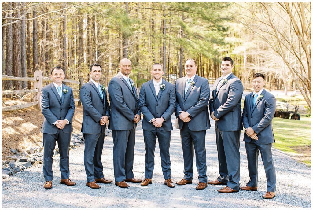 Formal portrait of the groom with his groomsmen in grey suits and blue ties.