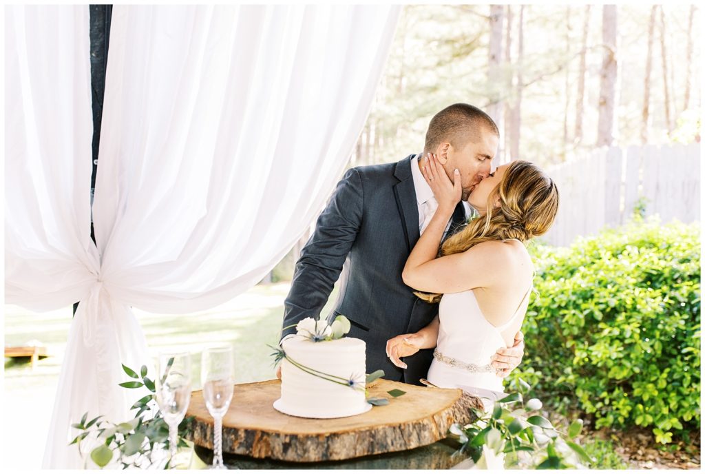 Delaney and David share a kiss after cutting their single layer wedding cake.