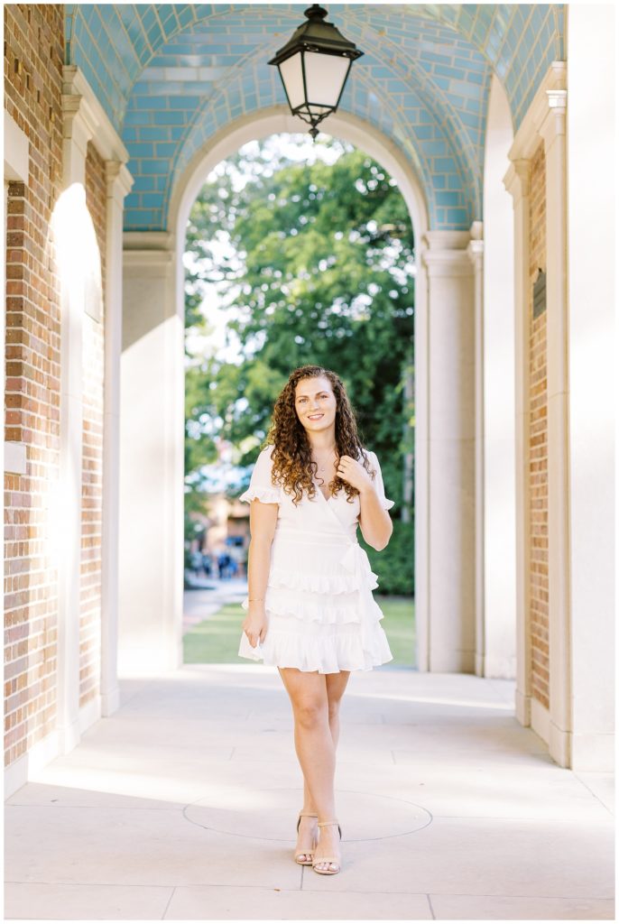 UNC Senior Photo at the Bell Tower wearing a white dress.