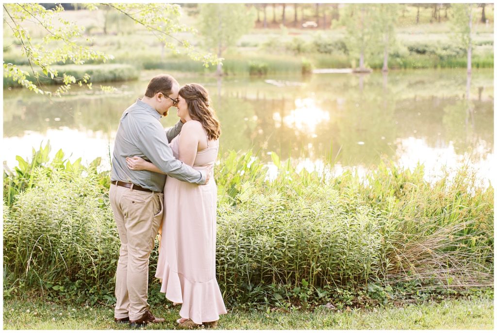 Raleigh Engagement photos by a pond with greenery and a light blush dress.