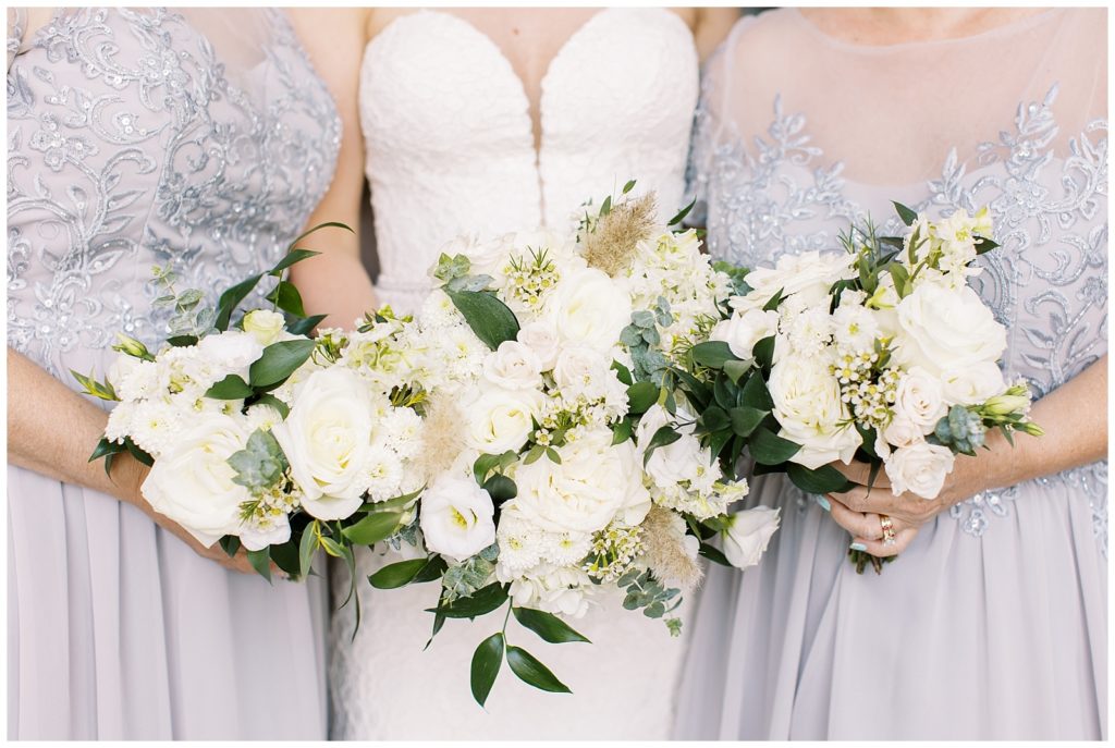 The bride and her matrons of honor had beautiful white and green lush florals for their beach wedding.