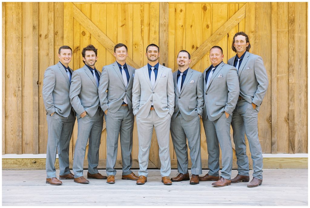 The groom and his groomsmen wore grey suits with navy shirts from mens wearhouse.