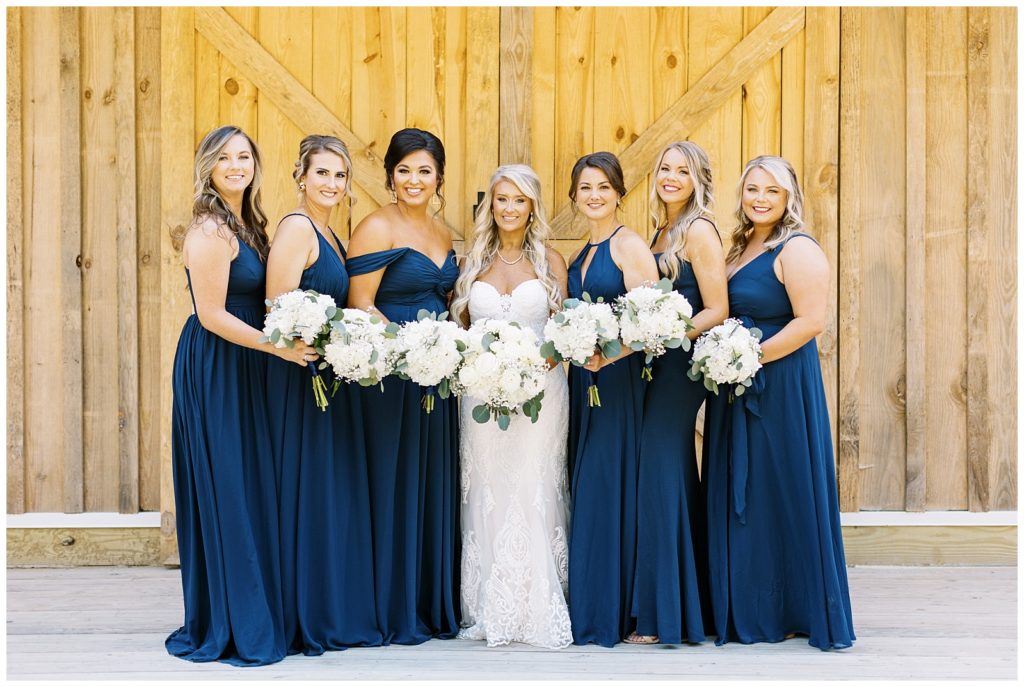 The bridesmaids wore navy dresses from azazie with white floral bouquets.