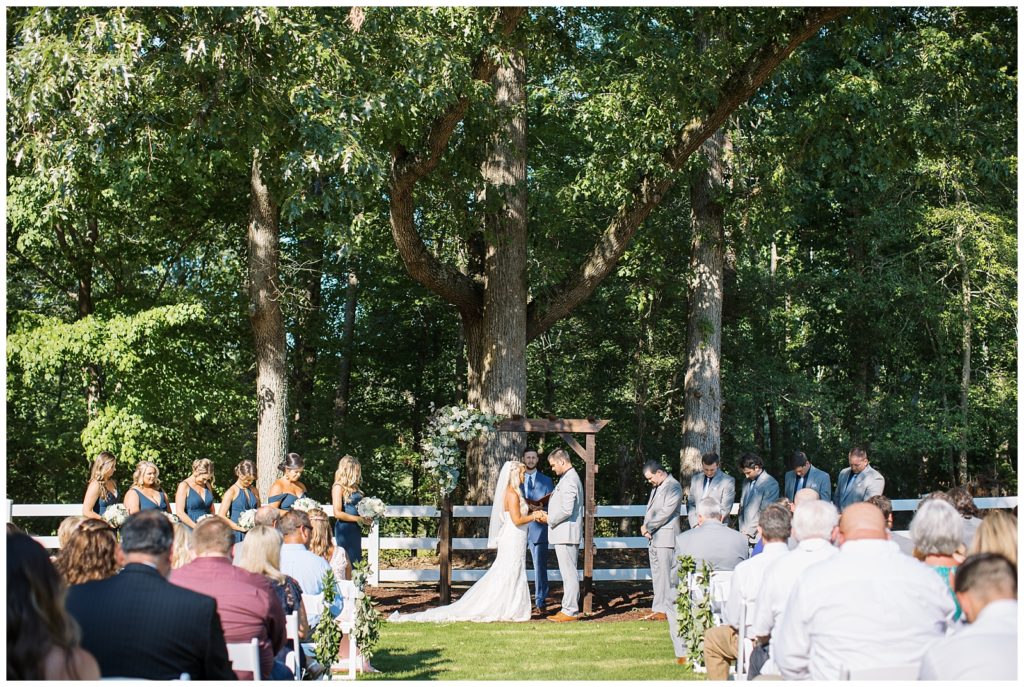 An outdoor ceremony at Twin Oaks Barn under trees.