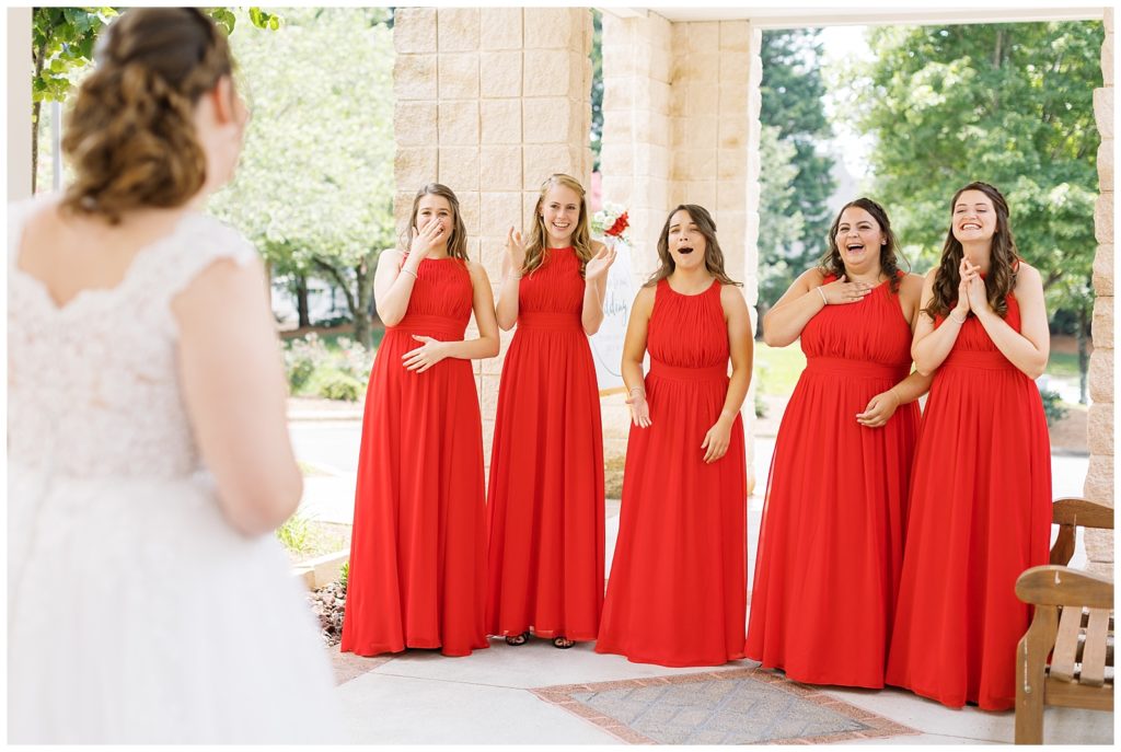 The bridesmaids react to seeing the bride for the first time.