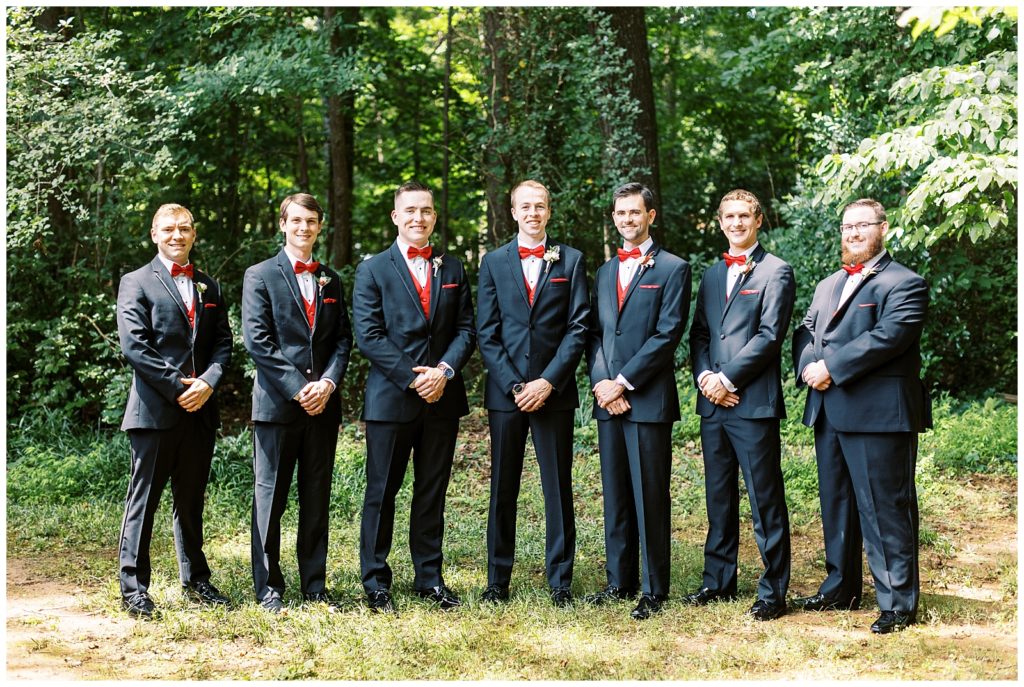 The groomsmen all wore classic black tuxedos with red bow ties.