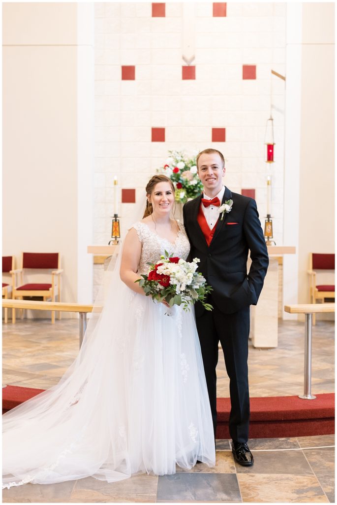 A formal portrait of the bride and groom together at the altar where they were married.