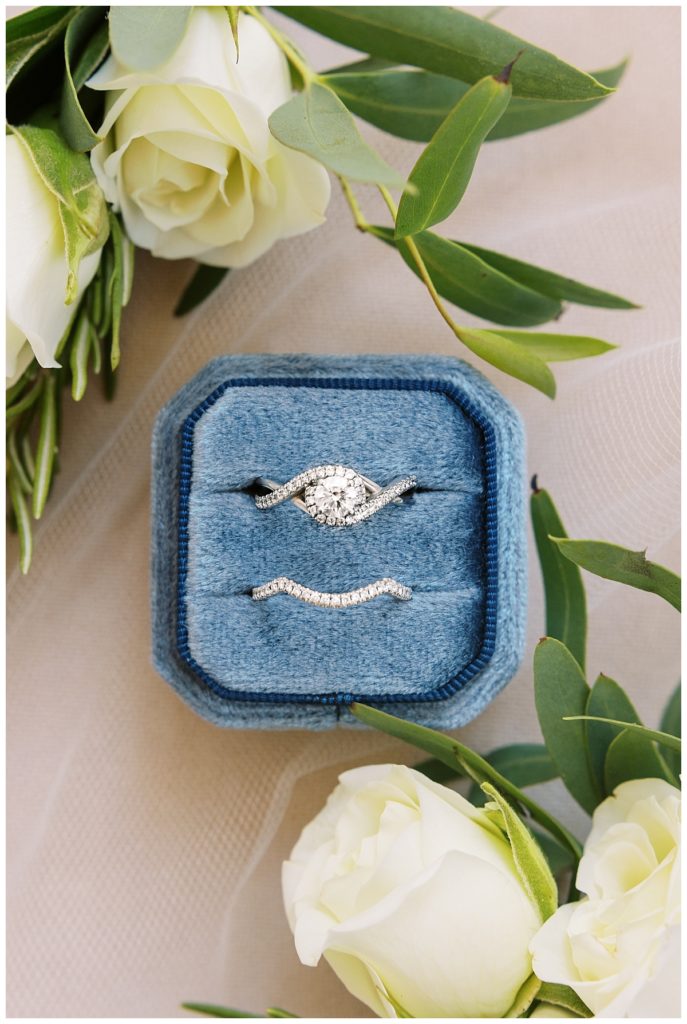 The bride's rings in a dusty blue velvet ring box.