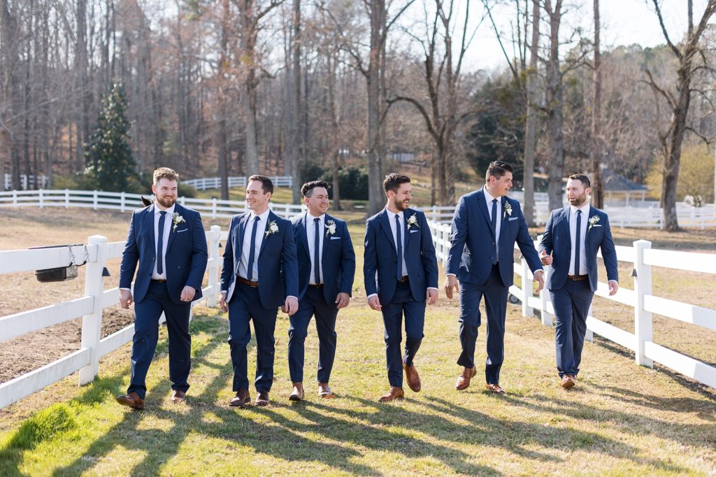 The groom and groomsmen walking around the farm at Seven Paths Manor | Raleigh Wedding Photographer