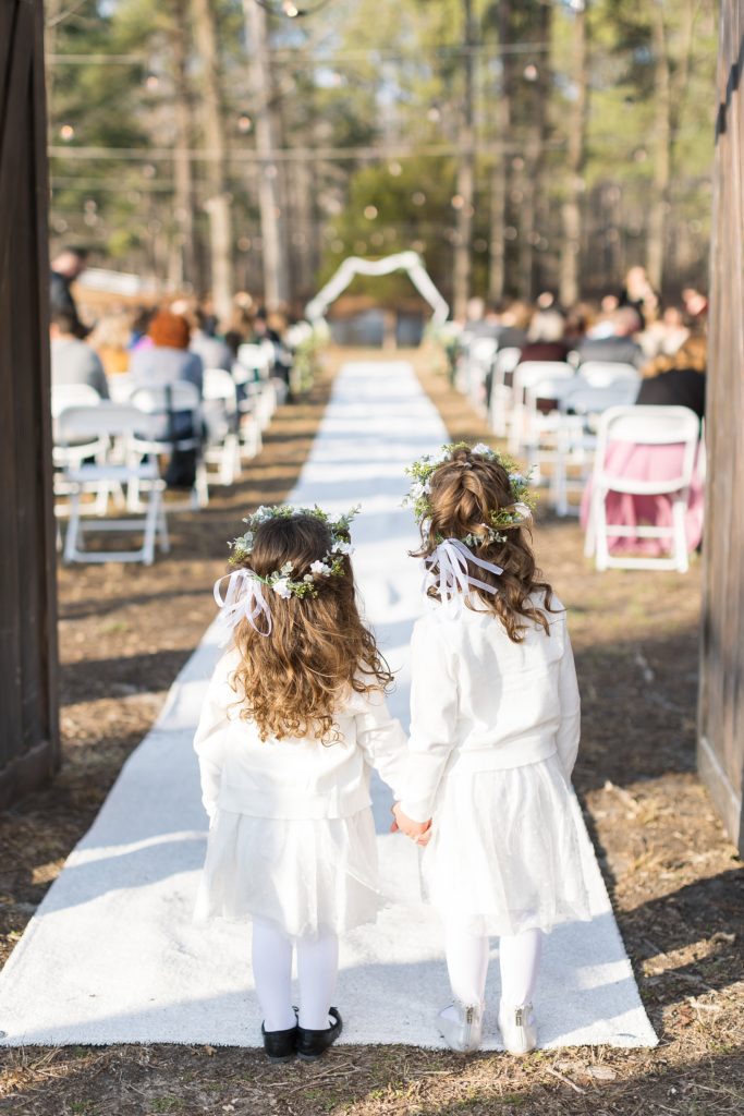 The flower girls hold hands before walking down the aisle | Raleigh Wedding Photographer