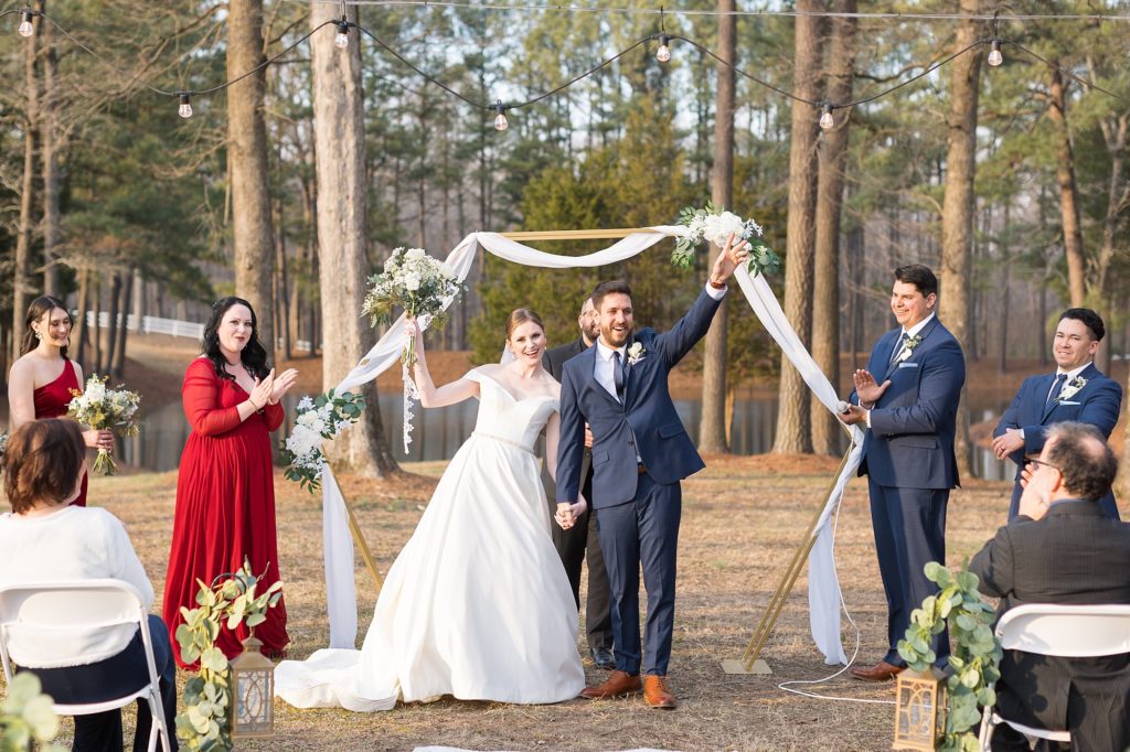 The bride and groom cheer as they are announced husband and wife | Raleigh Wedding Photographer