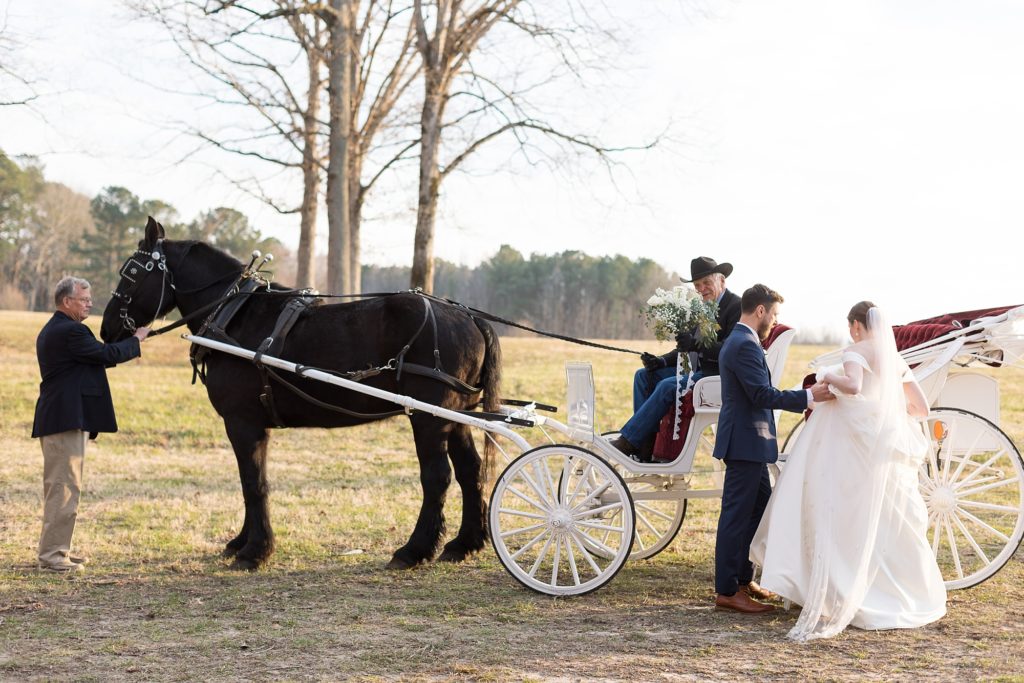 The groom helps his bride into a carriage after the ceremony | Raleigh Wedding Photographer