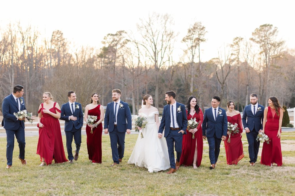 Walking through the fields during sunset with their wedding party | Raleigh Wedding Photographer