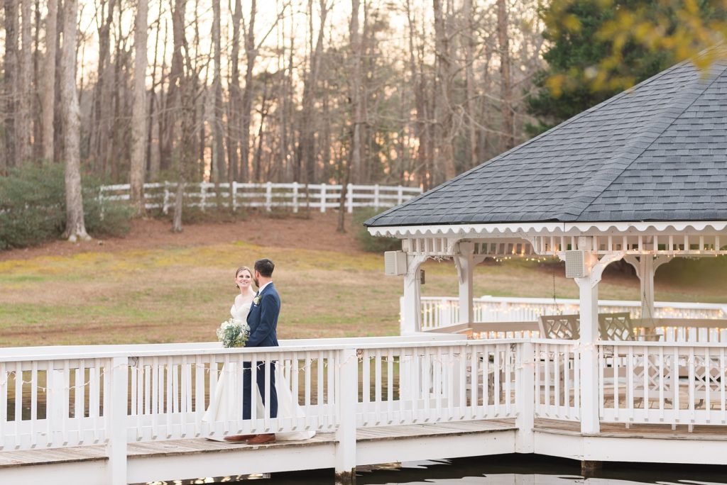 The bride and groom walking on a bridge over a pond | Raleigh Wedding Photographer