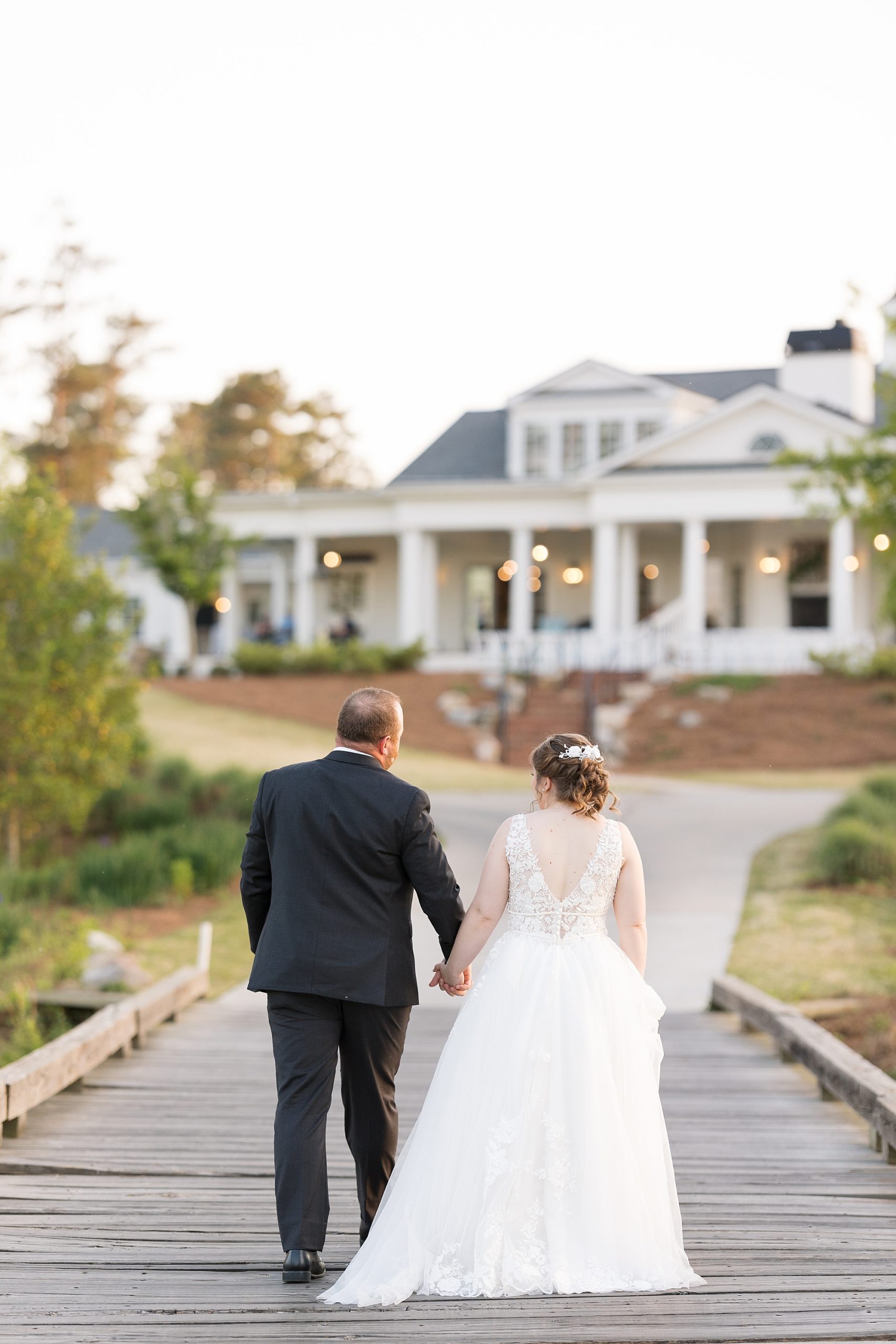 Bride and groom walking on bridge - Raleigh NC Wedding Photographer - Sarah Hinckley Photography