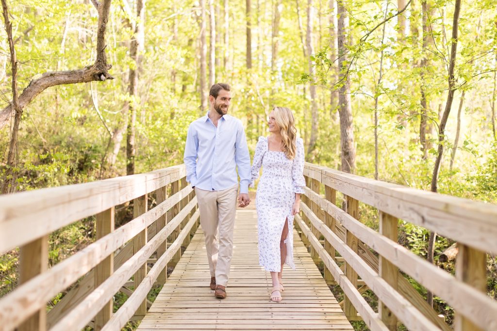 couple holding hands on the way to Catawba River  | Raleigh NC Wedding Photographer