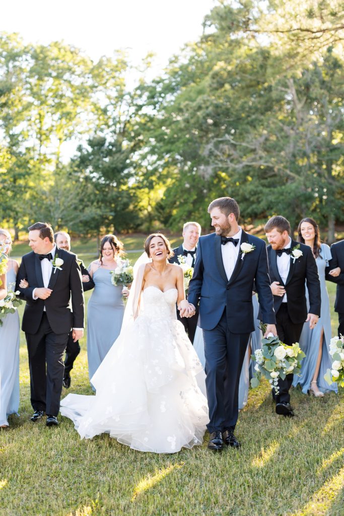 couple with their wedding party laughing  | Raleigh NC Wedding photographer