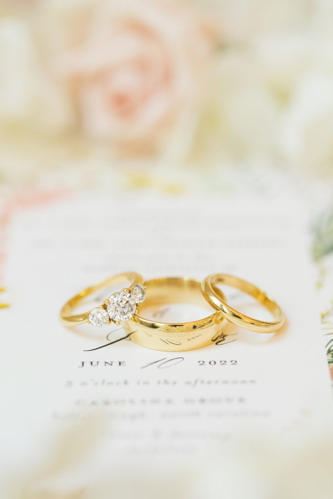 Gold wedding rings laying on an invitation | Carolina Grove | Raleigh NC Wedding Photographer | Sarah Hinckley Photography