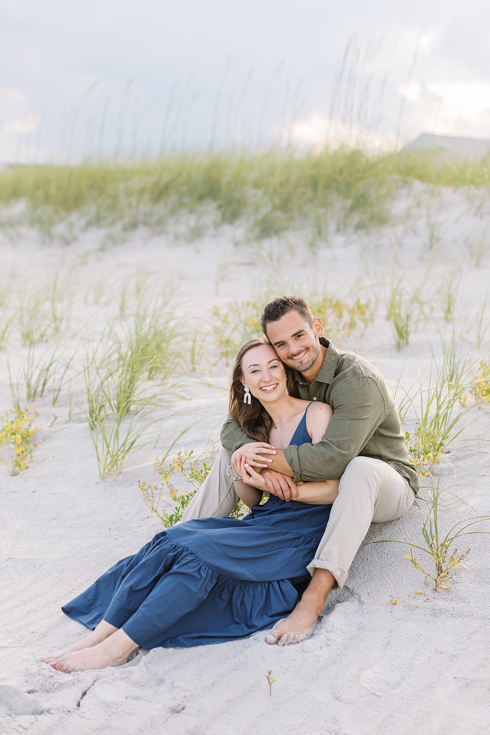 Engagement photos sitting near the sand dunes at Topsail | Raleigh North Carolina Wedding Photographer