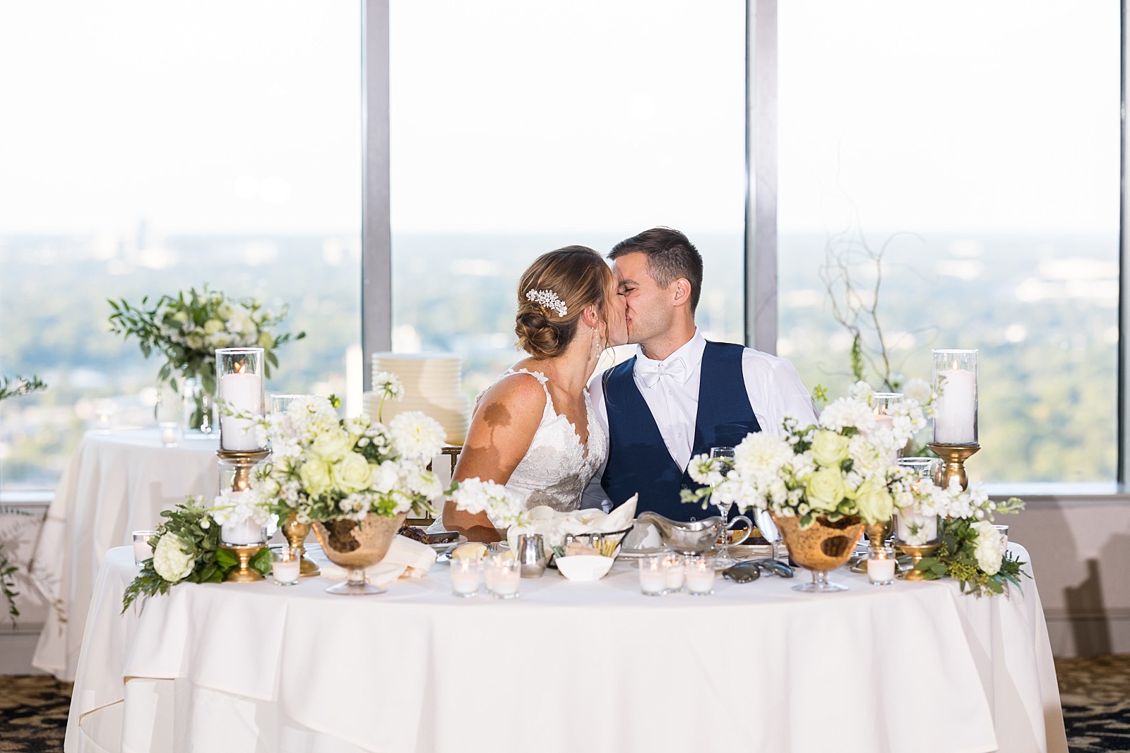 Bride and groom kissing at sweetheart table | Raleigh Wedding Photographer Sarah Hinckley