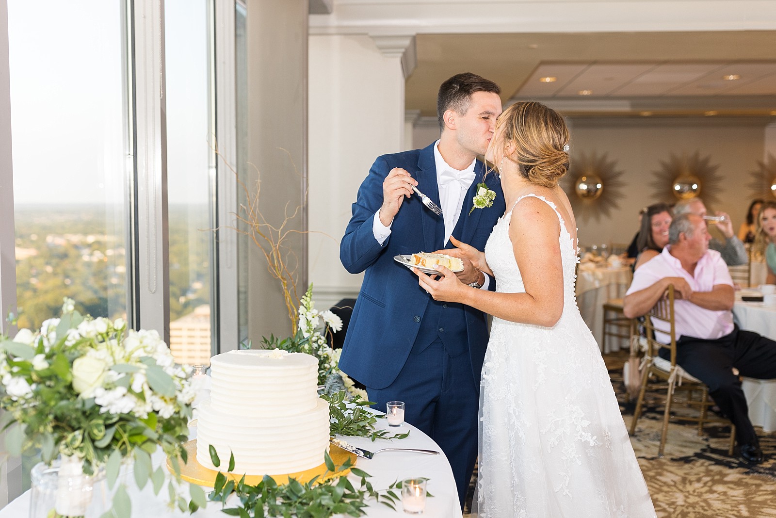 Bride and groom kissing during cake cutting | Raleigh Wedding Photographer Sarah Hinckley