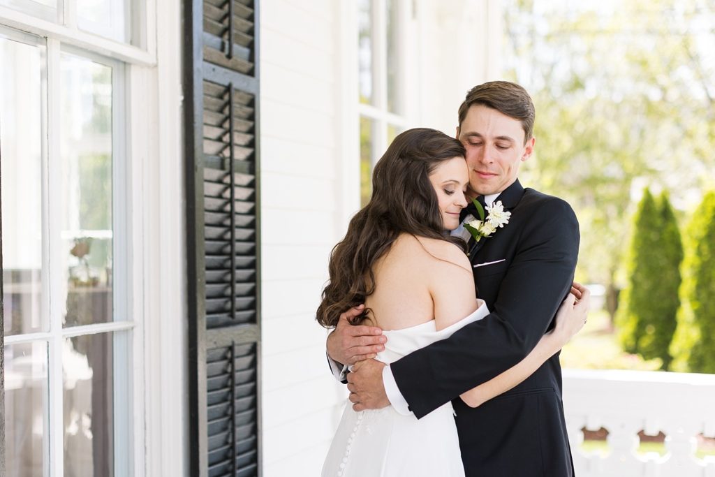 A bride and groom share a hug after their private first look at Merrimon-Wynne in Raleigh