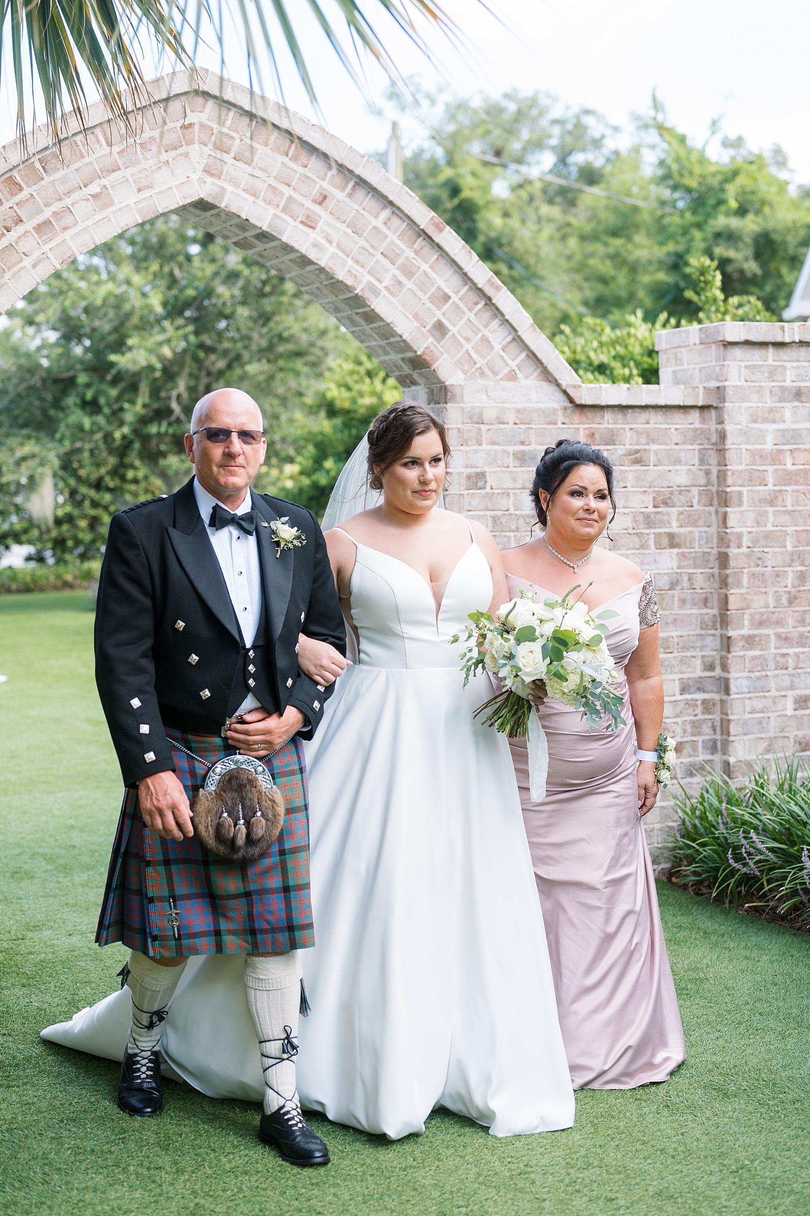 The bride walks down the aisle with her father and mother at Wrightsville Manor 