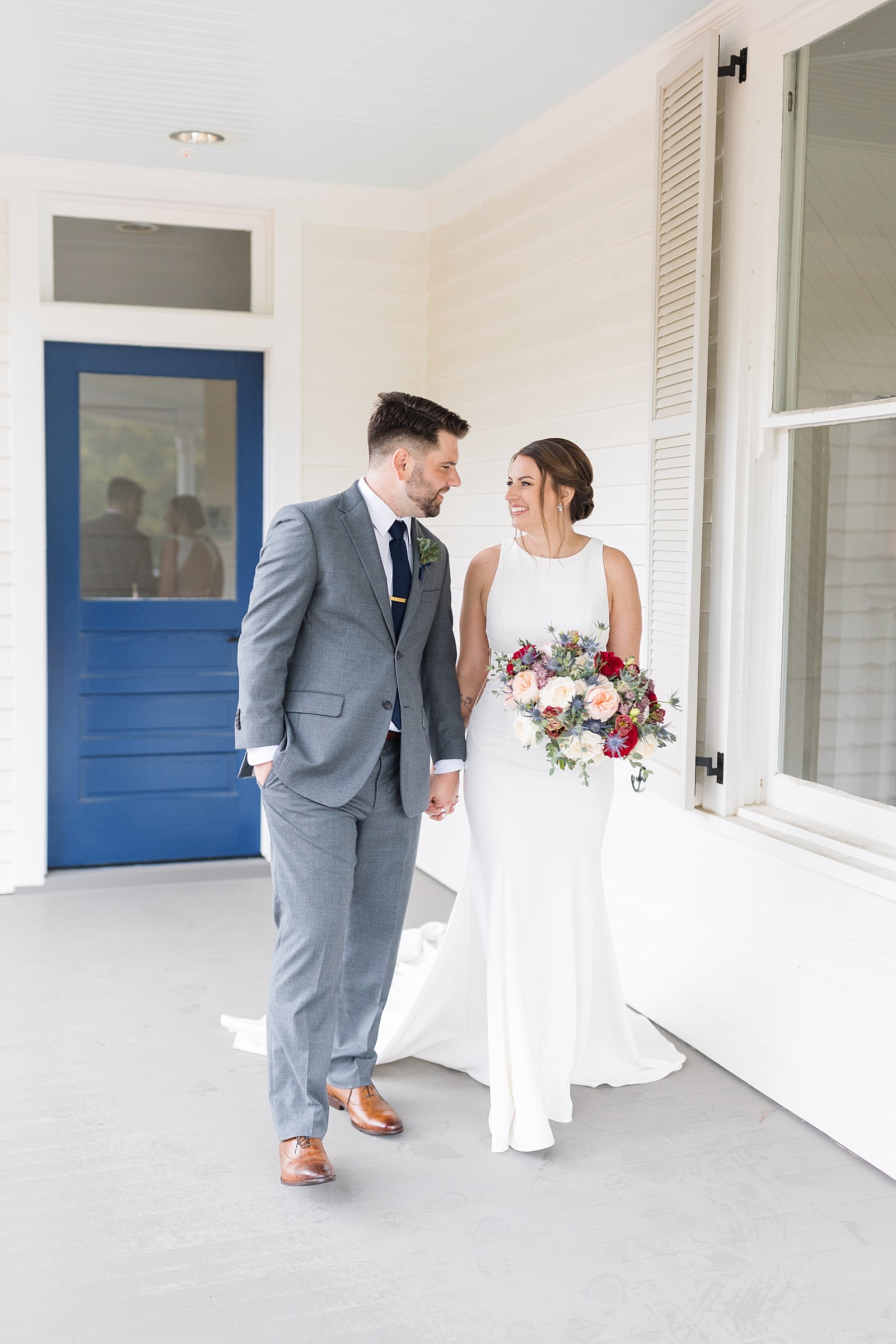 bride and groom in front of blue door  | Raleigh NC Wedding Photography