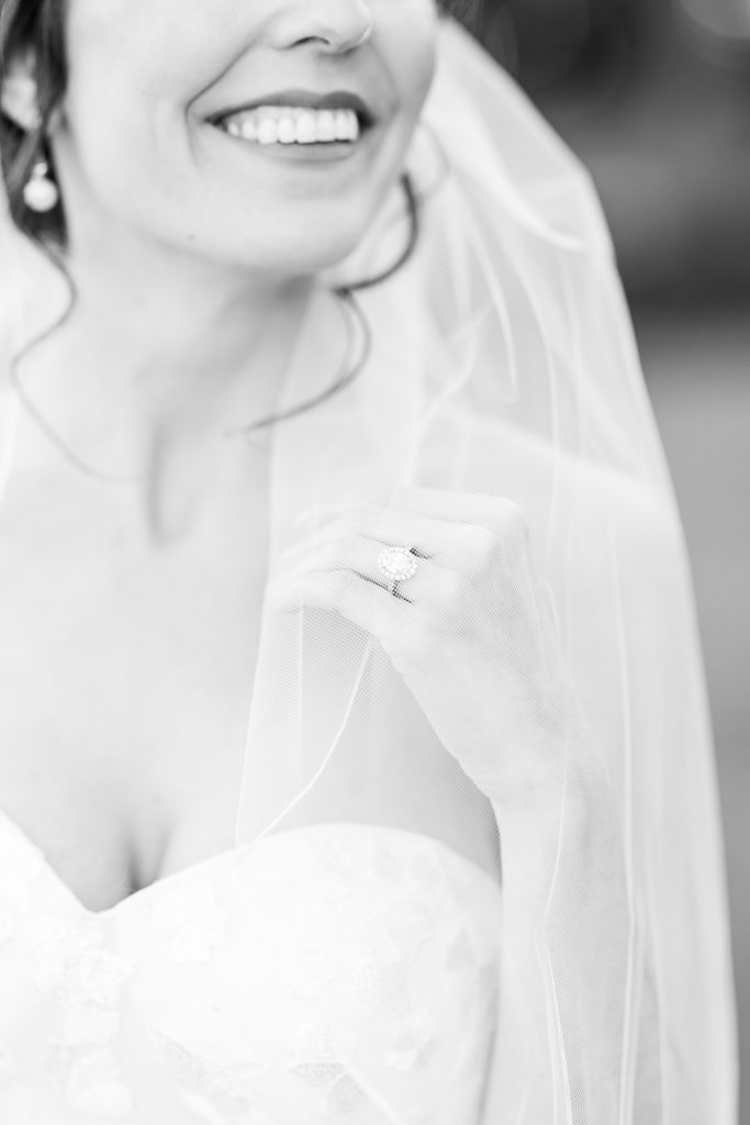 Black and white bridal portrait showing off her jewelry and her smile