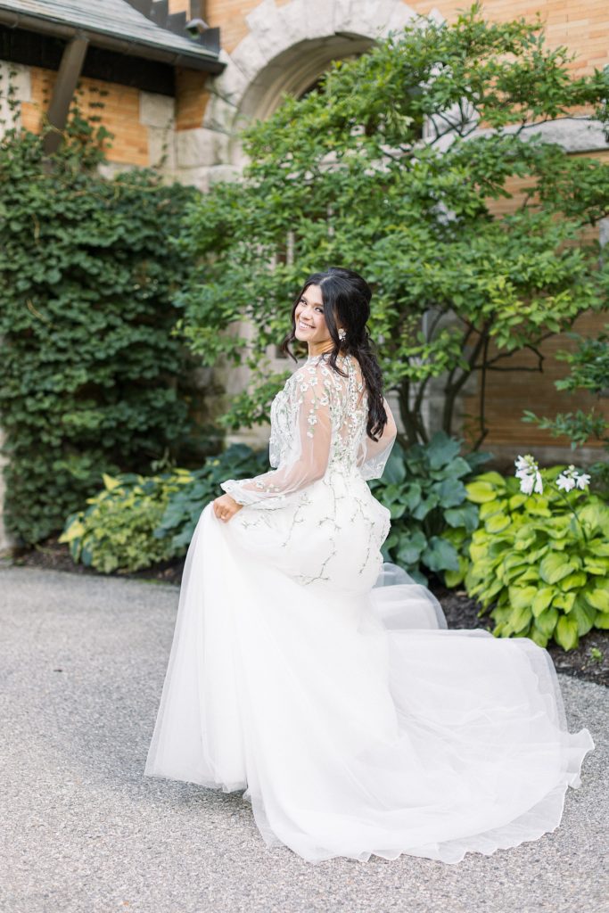 A bride with an embroidered dress running away from the camera laughing