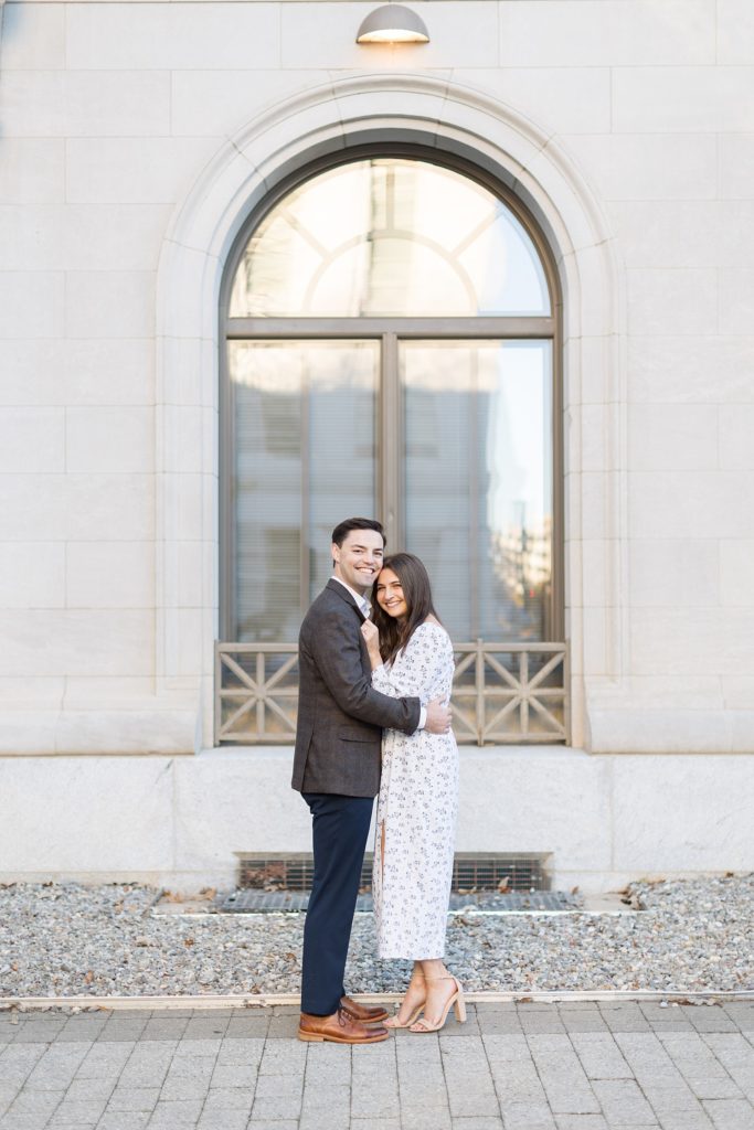 Couple embracing in front of arched window | Downtown Raleigh Engagement Photoshoot | Raleigh NC Wedding & Engagement Photographer | Sarah Hinckley Photography 