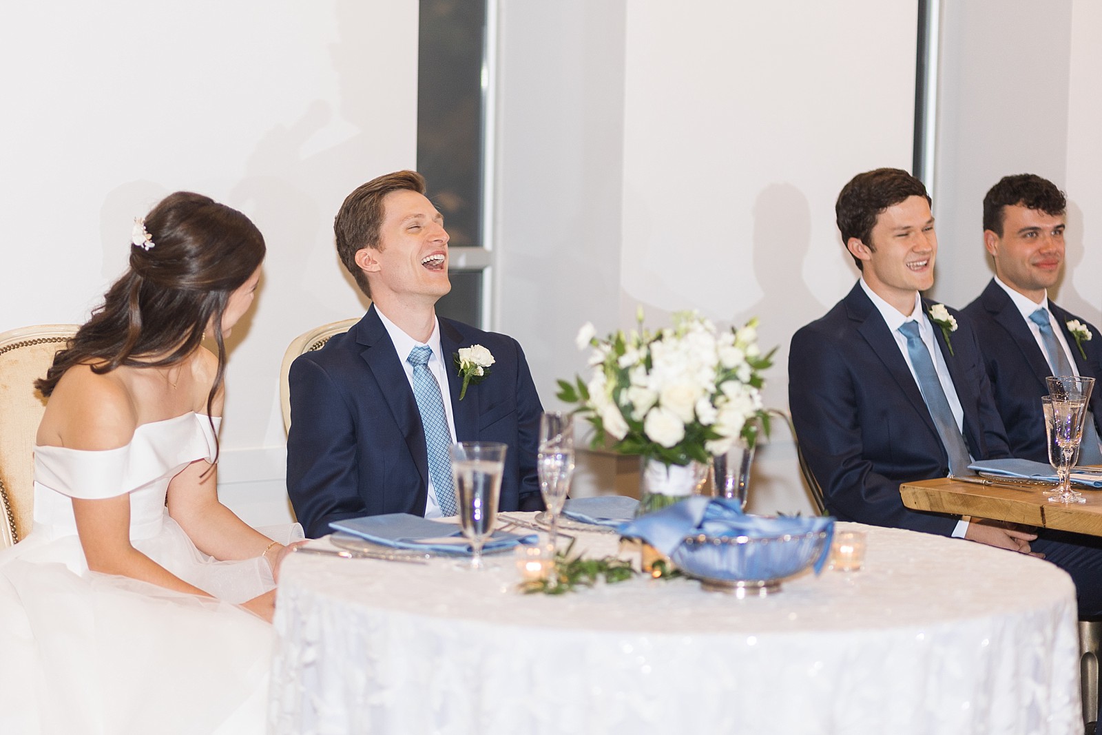 Bride and groom laughing at father of the groom speech  | The Meadows in Raleigh | Raleigh NC Wedding Photographer