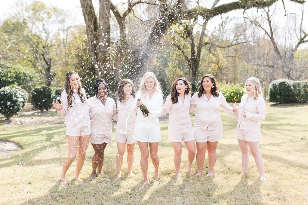 bride popping champagne with her bridesmaids  | Fall wedding at Walnut Hill in Raleigh NC | Raleigh NC wedding photographer 