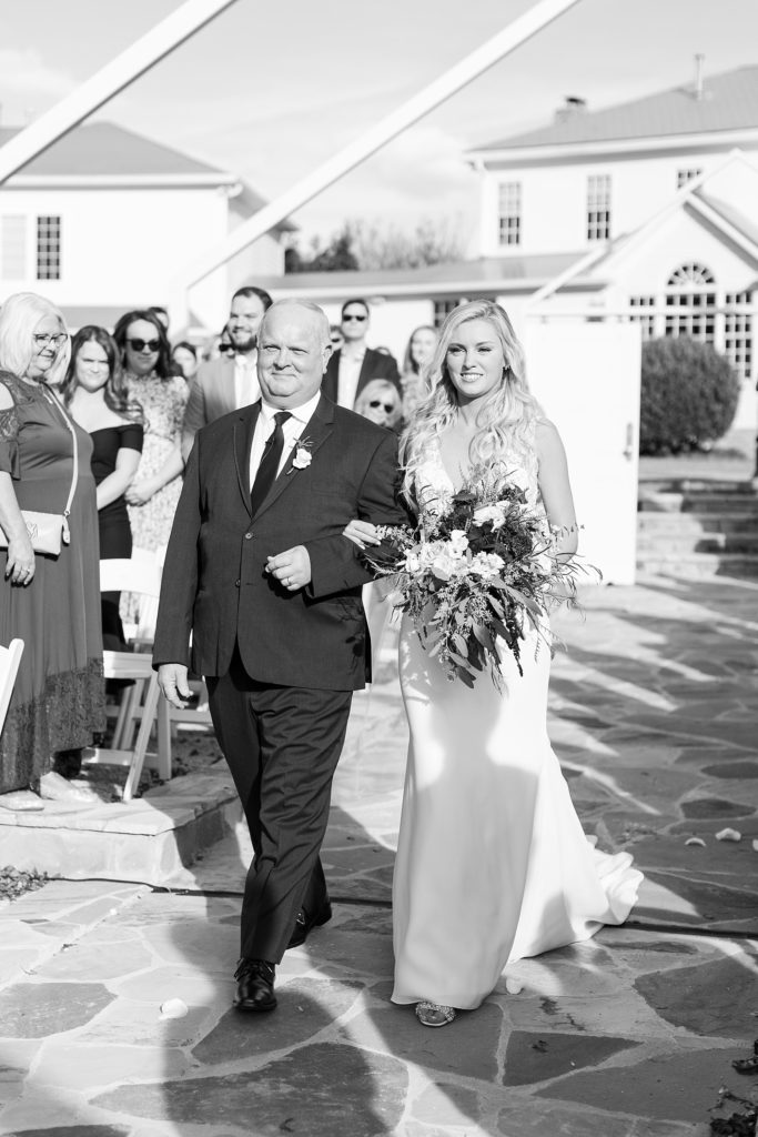 black and white of bride and her father walking down the aisle  | Fall wedding at Walnut Hill in Raleigh NC | Raleigh NC wedding photographer 