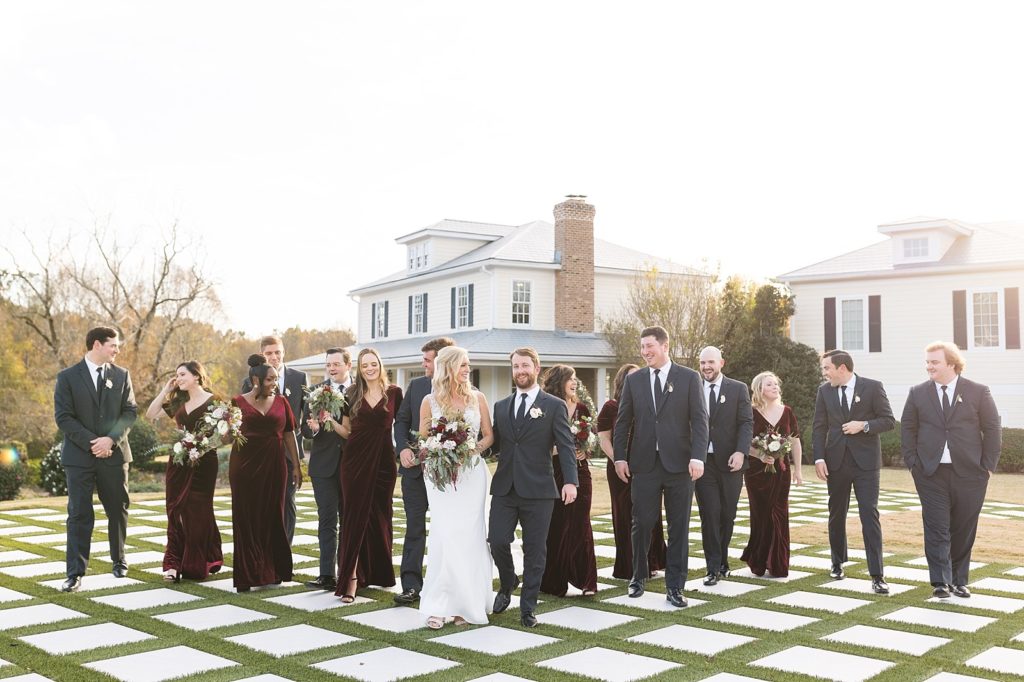 wedding party walking across checkered lawn | Fall wedding at Walnut Hill in Raleigh NC | Raleigh NC wedding photographer 