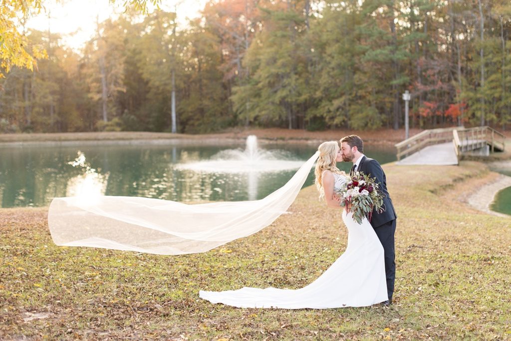 bride and groom with veil blowing in the wind | Fall wedding at Walnut Hill in Raleigh NC | Raleigh NC wedding photographer 