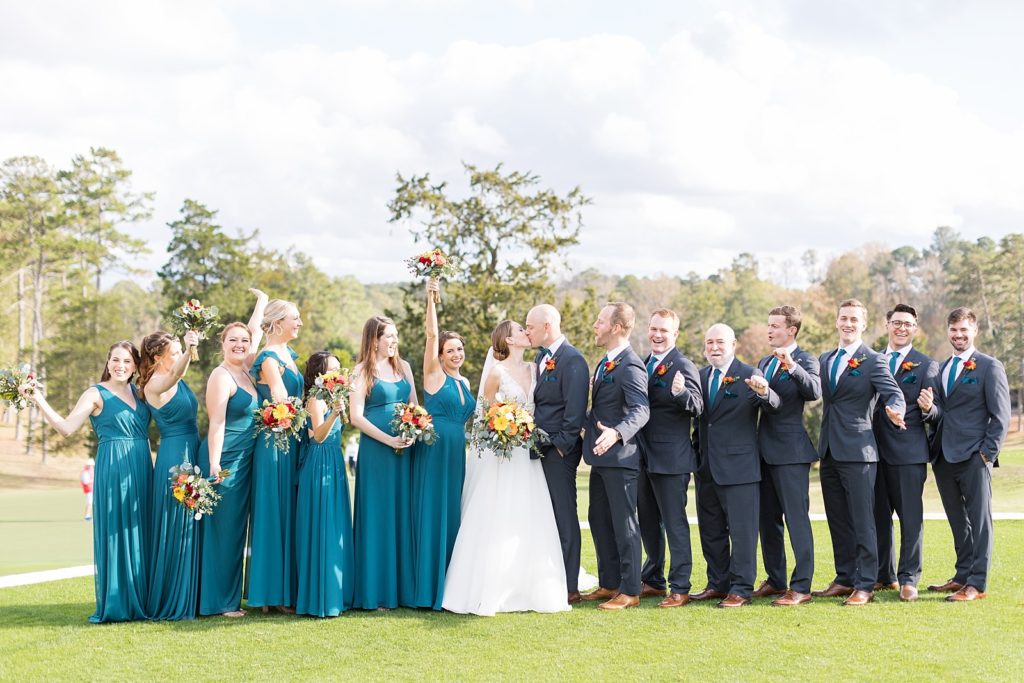Wedding party celebrating as bride and groom kiss | Fall wedding at Hope Valley Country Club | Durham Wedding | Raleigh NC wedding photographer 