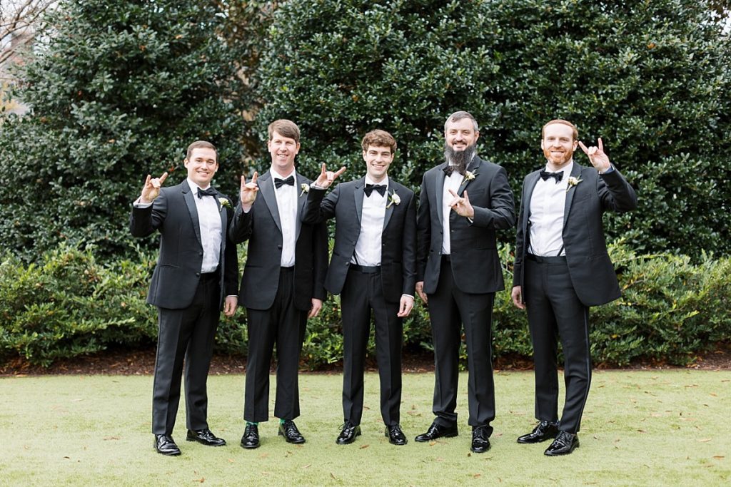 Groomsmen throwing up the NC State wolf pack hand sign | Classic Black and white wedding at Merrimon-Wynne | Raleigh NC Wedding Photographer 