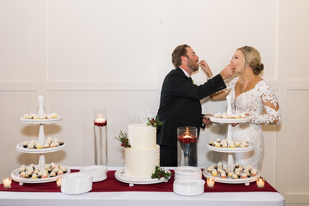 Bride and groom feeding each other's cake | Christmas Wedding at Pinehill Pavilion | Raleigh NC Wedding Photographer 