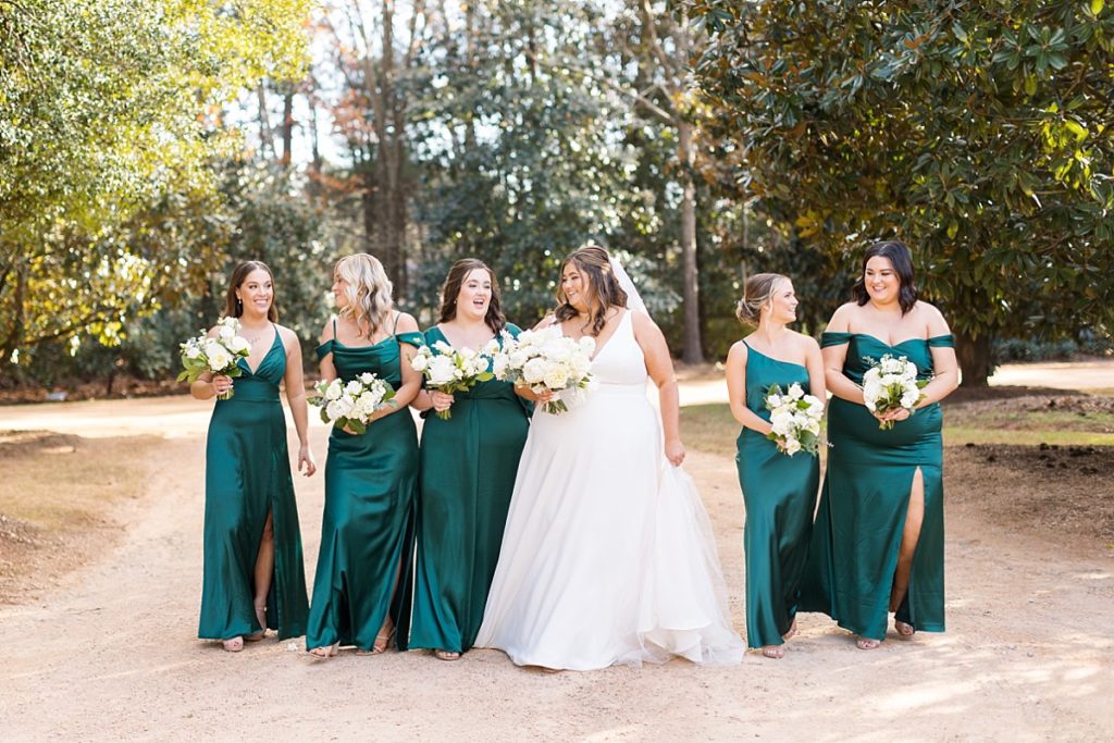 Bride with her bridesmaids walking | Emerald Christmas Wedding at The Sutherland Estate | Raleigh NC Wedding Photographer