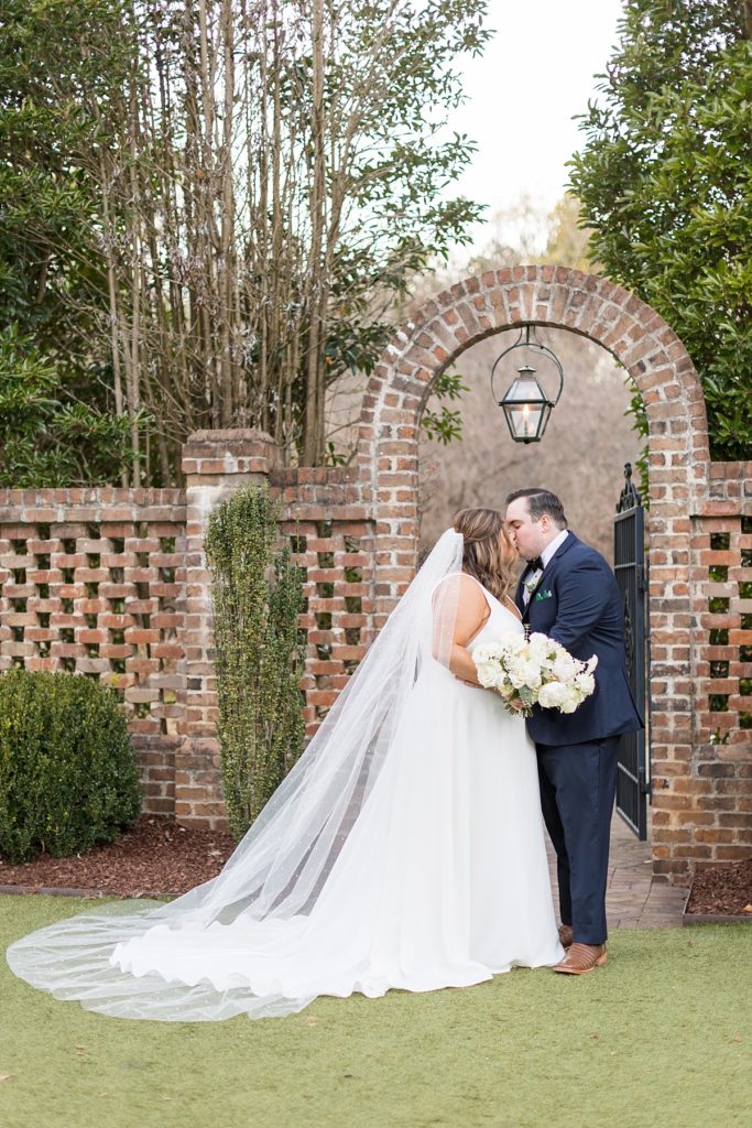 Bride and groom kissing under gas lit lamp | Emerald Christmas Wedding at The Sutherland Estate | Raleigh NC Wedding Photographer