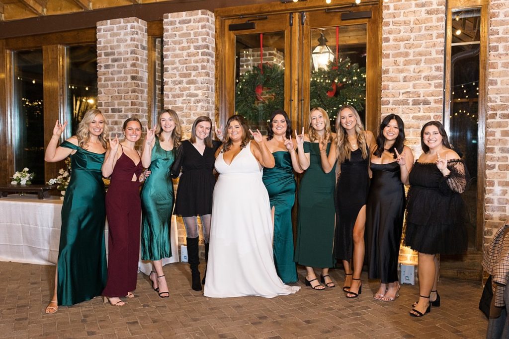 Bride and her friends throwing up the NC State Wolf Pack sign | Emerald Christmas Wedding at The Sutherland Estate | Raleigh NC Wedding Photographer