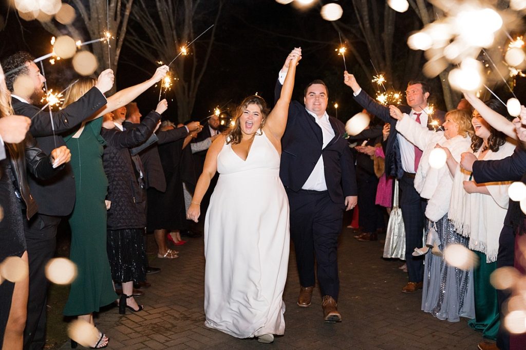 Bride and groom walking through their sparkler exit  | Emerald Christmas Wedding at The Sutherland Estate | Raleigh NC Wedding Photographe