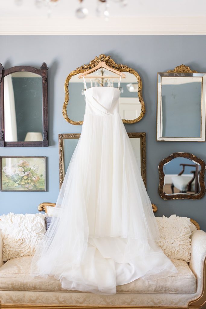 Wedding dress hanging in front of vintage mirror gallery wall | Raleigh NC wedding photographer