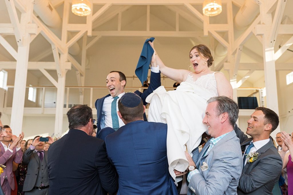 Bride and groom being lifted in chairs | Raleigh NC wedding photographer 