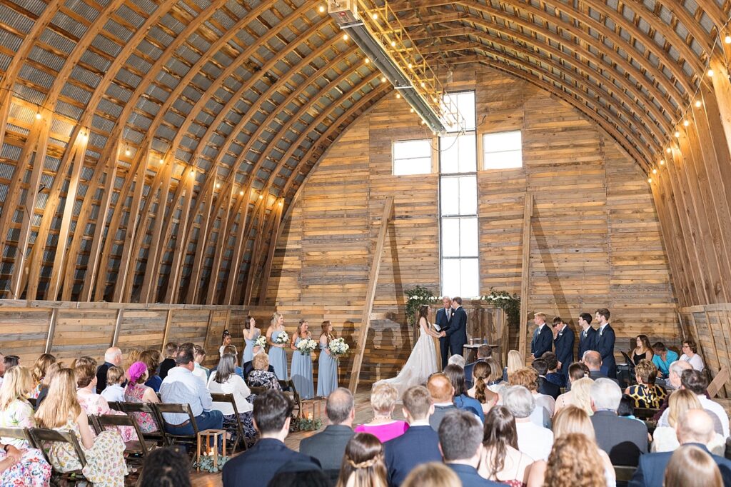 Bride and groom holding hands during ceremony | Amazing Graze Barn Wedding | Amazing Graze Barn Wedding Photographer
