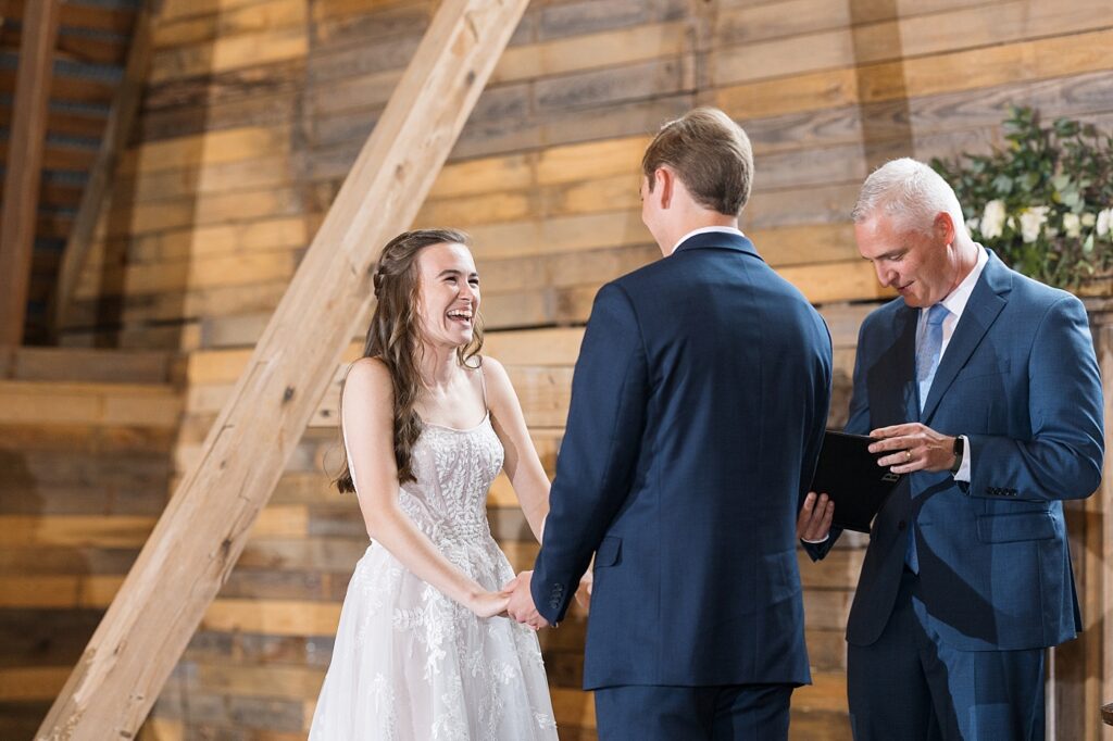 Bride and groom holding hands during ceremony | Amazing Graze Barn Wedding | Amazing Graze Barn Wedding Photographer