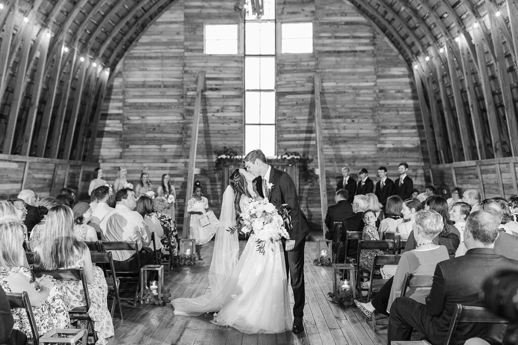 Bride and groom holding kissing after ceremony | Amazing Graze Barn Wedding | Amazing Graze Barn Wedding Photographer